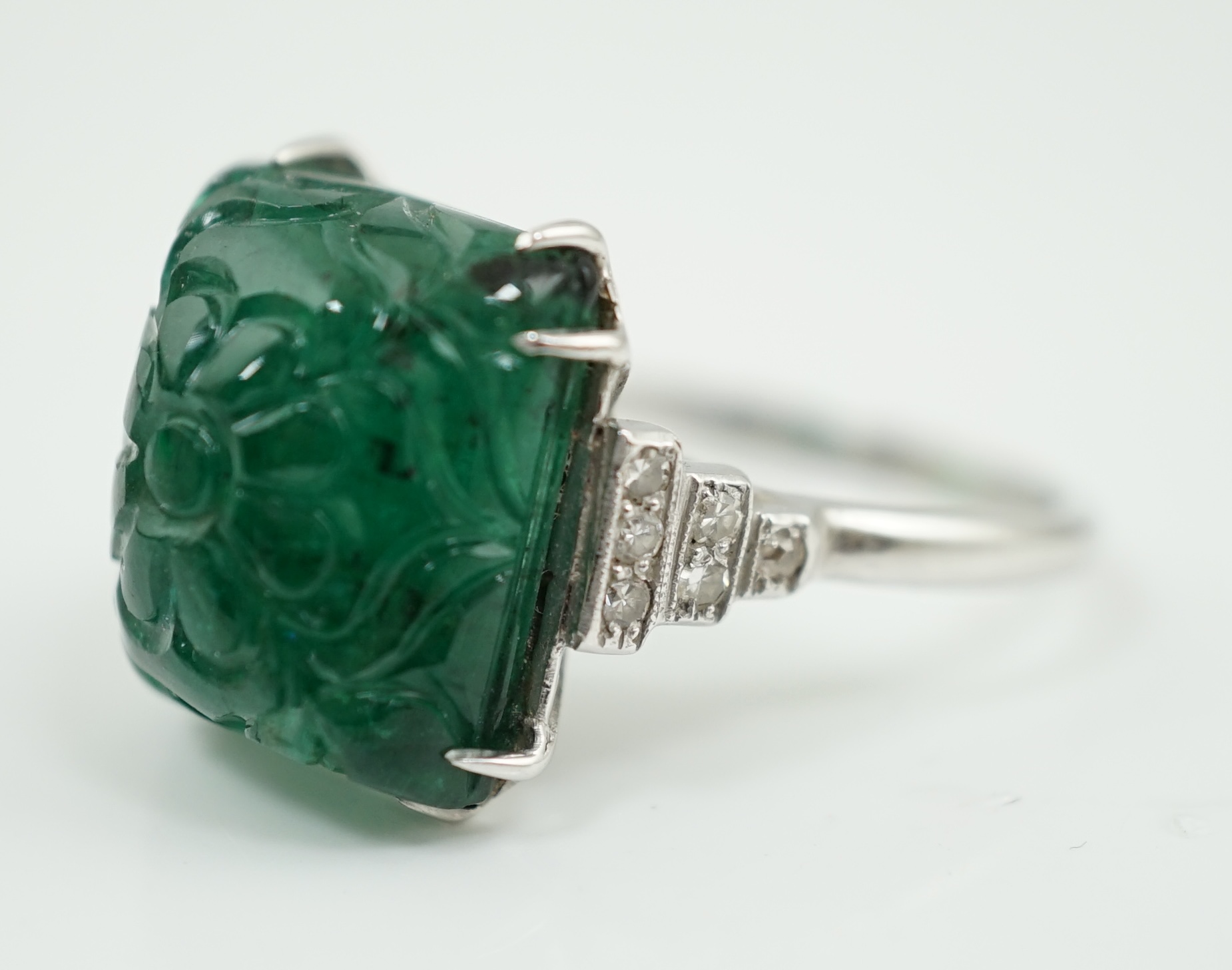 A French 1920's style platinum and single stone emerald set dress ring, with twelve stone millegrain set diamond stepped shoulders